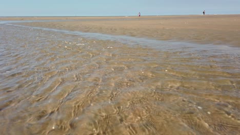 Ein-Klarer-Wasserstrom-Am-Strand-Mit-Weißem-Sand