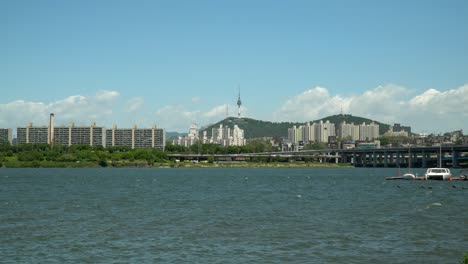 Río-Han-Cerca-Del-Puente-Banpo,-Torre-Namsan-N-Seoul-En-El-Fondo,-Catamarán-Y-Velero-Flotando-En-El-Muelle,-Gran-Angular,-Estático