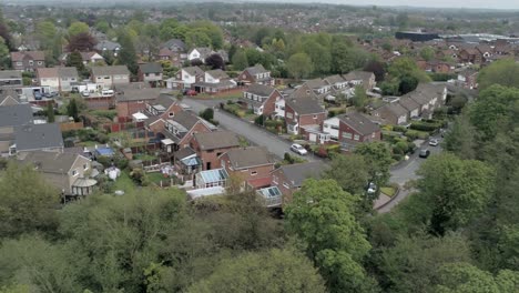 Quiet-British-homes-and-gardens-residential-suburban-property-aerial-view-right-orbit-above-trees