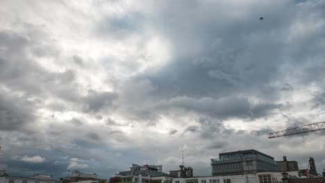 An-immersive-time-lapse-of-dark-swirling-low-level-nimbostratus,-stratus-and-cumulus-clouds-pass-over-rooftops-and-buildings-during-a-summer-thunderstorm