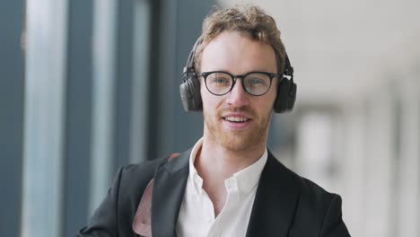 Close-up-portrait-of-an-adult-curly-man-in-headphones-and-glasses