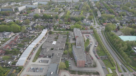 Flying-over-apartment-building-in-busy-suburban-town