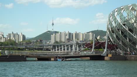 Distant-View-Of-Namsan-Tower-From-Han-River-In-Seoul-With-Sebitseom,-Artificial-Floating-Island-Popular-In-South-Korea
