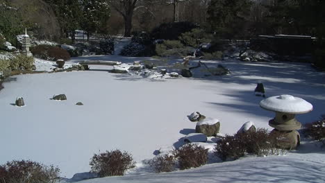 Frozen-snow-covered-pond-in-Japanese-garden-in-winter