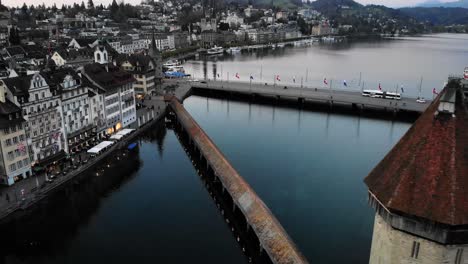 Aerial-footage-from-Lucerne,-Switzerland-from-up-above-the-historical-Kapellbrücke-towards-the-lake