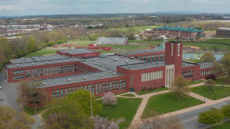 Rising-aerial-reveals-large-red-brick-academic-school-university-building-exterior