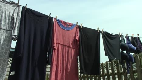 Clothes-hanging-on-a-washing-line-using-wooden-pegs-in-the-back-garden-of-a-home-in-Oakham-in-the-county-of-Rutland-in-England,-United-Kingdom