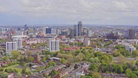 Aerial-drone-reveal-shot-flying-backwards-over-Birmingham-with-view-of-city-centre,-England