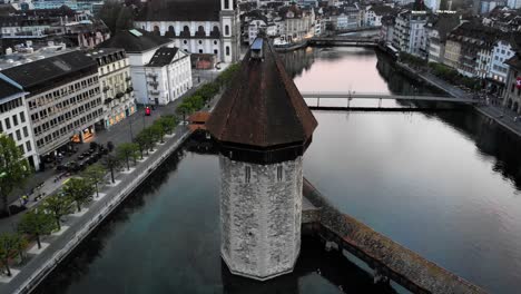 Aerial-footage-with-spinning-view-of-Kappelbrücke-bridge-in-Lucerne,-Switzerland-at-sunset
