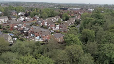 Ruhige-Britische-Häuser-Und-Gärten-Wohnvorstadtgrundstück-Luftaufnahme-Orbit-Links-über-Bäumen