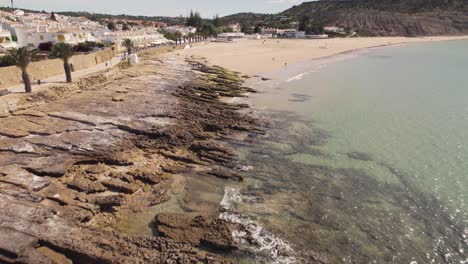 Palm-trees-along-Praia-da-Luz-beach-shores,-Algarve