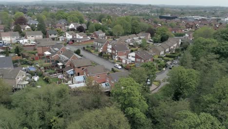 Quiet-British-homes-and-gardens-residential-suburban-property-aerial-view-left-orbit-over-trees