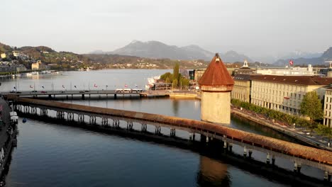 Afternoon-aerial-view-of-Kappelbrücke-bridge-in-Lucerne,-Switzerland-while-moving-towards-the-lake