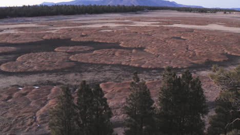 Aerial-flyover-dry-lake-bed-and-mountain-in-background-during-climate-change