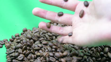 Woman's-hand-grabbing-coffee-beans,-green-screen
