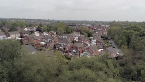 Ruhige-Britische-Häuser-Und-Gärten-Vorstadtgrundstück-Luftbild-Absteigend-über-Bäume-Kippen