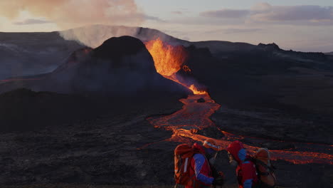 Close-up-shot-of-two-search-and-rescue-worker-in-protective-suit-talking-about-safety-in-front-of-erupting-Volcano-in-Iceland