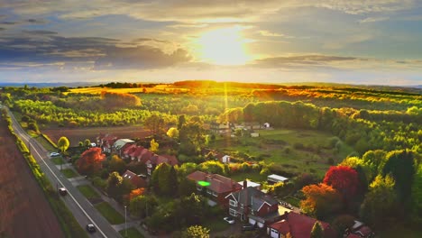 Aerial-drone-shot-rising-up-over-countryside-housing-estate-in-golden-hour
