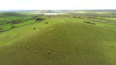 A-drone-pan-across-a-plush-green-valley-on-a-hazy-morning