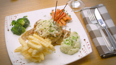 Mustard-chicken-with-French-fries,-salad,-and-grated-cheese,-Mediterranean