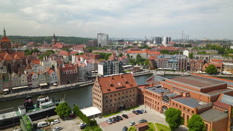 Polish-Baltic-Frederic-Chopin-Philharmonic-and-Hotel-KROLEWSKI-courtyard-with-many-cars-parked-near-the-buildings,-Nova-Motlawa-riverbank-in-Old-Town-Gdansk,-Poland-on-a-cloudy-day