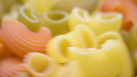 Pfeife-Rigate-Pasta-Tricolore,-Makroaufnahme,-Pfeife-Rigate-Pasta-Tricolore-Auf-Dem-Tisch,-Der-Sich-Nach-Rechts-Dreht