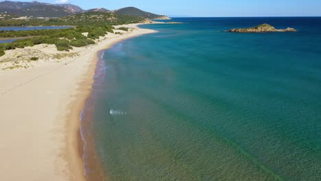 Aerial-pedestal-shot-of-beautiful-Su-Giudeu-beach-without-people-to-incredible-views-of-turquoise-water,-lagoons-and-hills-in-South-Sardinia,-Italy