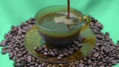 Pouring-hot-coffee-into-the-cup,-coffee-beans,-green-screen