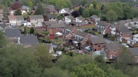 Quiet-British-homes-and-gardens-residential-suburban-property-aerial-view-dolly-left-above-trees