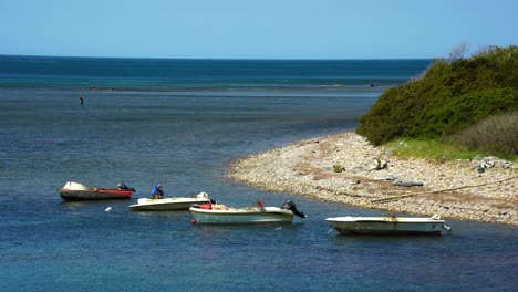 Barcos-De-Pesca-Estacionados-En-La-Tranquila-Bahía-Del-Mar,-Pescador-Preparando-Las-Redes-Y-El-Anzuelo