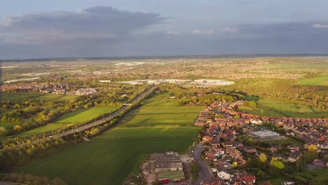 Aerial-view-of-English-town-houses-surrounded-by-countryside-fields,-Yorkshire