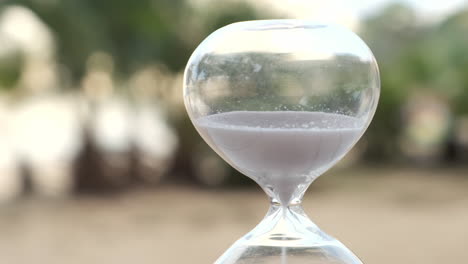 Hourglass-as-time-passing-on-wooden-table-with-bokeh-background