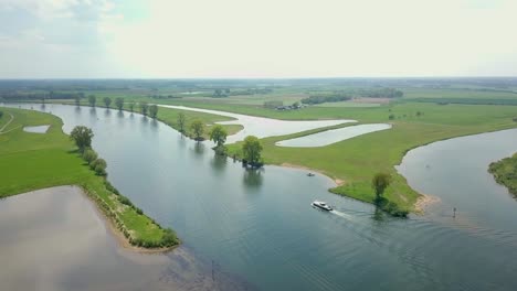 Aerial-drone-view-of-the-river-and-revealing-a-boat-is-passing-by-in-the-Netherlands