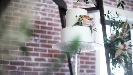 Low-angle-pov-of-fancy-and-beautiful-wedding-cake-on-crystal-high-stand