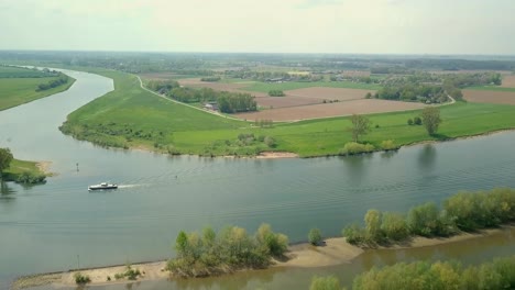 Luftdrohnenansicht-Des-Schönen-Flusses-In-Den-Niederlanden-Und-Ein-Boot-Fährt-An-Der-Szene-Vorbei