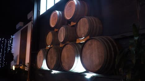 Gestapelte-Weinfässer-Durch-Holzwand-In-Einem-Weingut