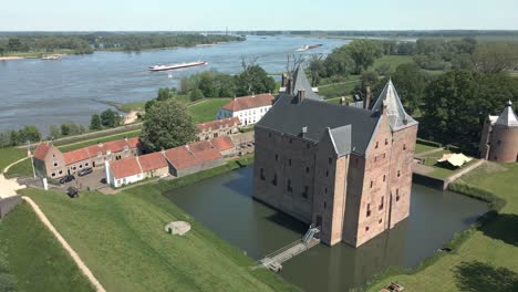 Birds-eye-view-of-monumental-UNESCO-Castle-Loevestein-near-river-Maas-in-the-Netherlands,-Aerial-shot-circling-around-castle-in-the-Netherlands