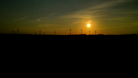 Silhouettierte-Windkraftanlagen-Drehen-Sich-Am-Horizont-Bei-Goldenem-Sonnenuntergang-In-Puck-Polen