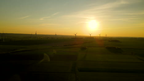 Windpark-Auf-Grünen-Feldern-Silhouetten-Bei-Sonnenuntergang-In-Puck-Polen,-Luftdrohne