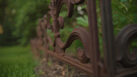 Rack-focus-down-small-rustic-gate-in-a-lush-backyard