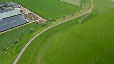 Aerial-drone-view-of-the-beautiful-road-at-the-dike-in-the-countryside-of-the-Netherlands,-Europe