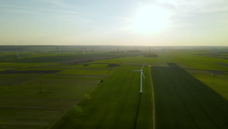 Wind-farm-over-green-fields-on-sunset-viewed-from-a-high-point,-Aerial-view-of-wind-turbines-slowly-rotating-under-the-wind-in-Puck,-Pomorskie,-Poland,-aerial-drone