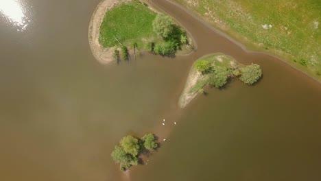 Vista-Aérea-De-Drones-De-Pequeñas-Islas-Disparadas-De-Arriba-Hacia-Abajo-En-El-Lago-En-Los-Países-Bajos