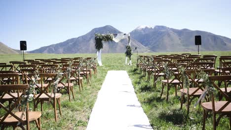 Empty-wedding-venue-in-outdoor-meadow-with-mountains-in-background