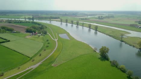 Aerial-drone-view-of-the-beautiful-countryside-road-and-landscape-near-the-river-in-the-Netherlands