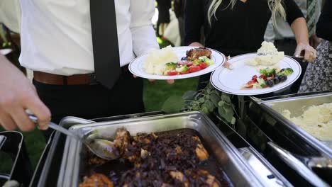 Close-up-shot-of-wedding-guest-serving-delicious-catered-food-during-mariage-party
