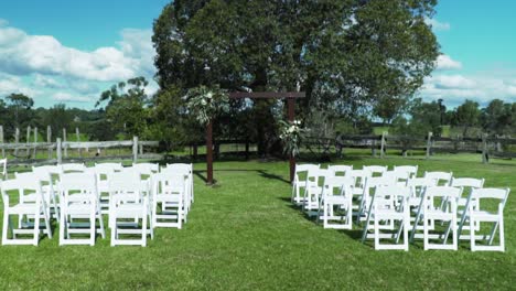 Wedding-Place-With-Wooden-Arch-And-White-Chairs-For-Outdoor-Wedding-Ceremony---wide-shot