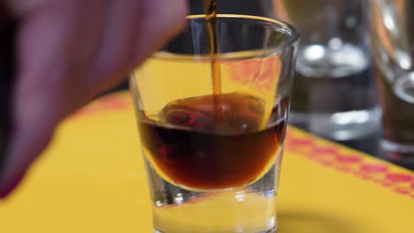Barkeeper-Gießt-Braunen-Schnaps-In-Ein-Schnapsglas-Und-Bereitet-Einen-B-52-Cocktail-Shot-Vor