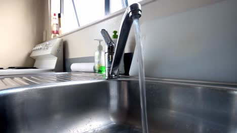 realtime-shot-of-a-tap-running-in-a-cheap-metal-sink