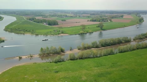 Luftdrohnenansicht-Des-Schönen-Flusses-In-Den-Niederlanden-Und-Einige-Boote-Fahren-An-Der-Szene-Vorbei